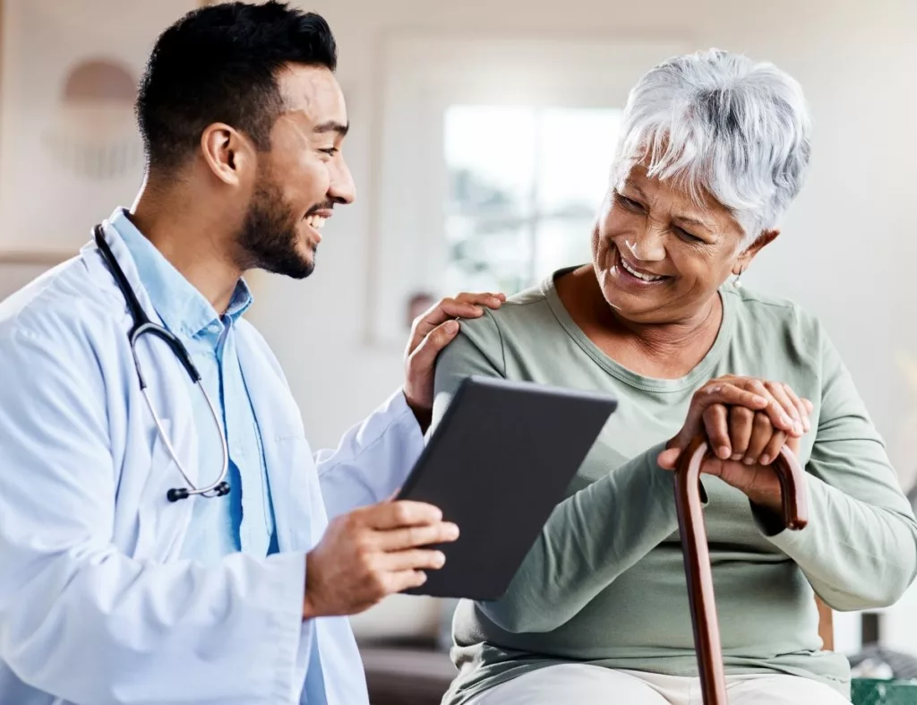 A doctor attentively converses with an elderly woman, providing medical guidance and support thanks to the County Medical Services Program.